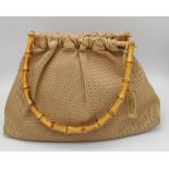 A Gucci Beige Perforated Leather Bamboo Handbag. Soft leather exterior with classic bamboo top