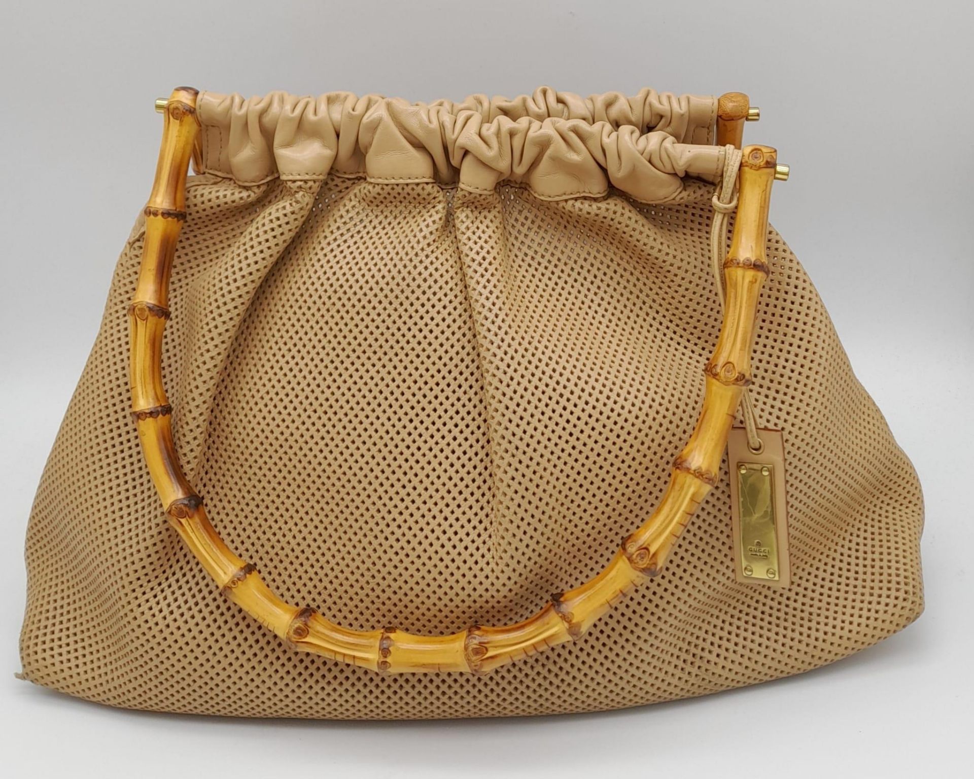 A Gucci Beige Perforated Leather Bamboo Handbag. Soft leather exterior with classic bamboo top