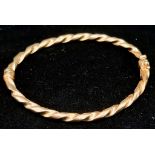 A Vintage 9K Yellow Gold Twist Bangle with Clip-Open Clasp and Tension Features. 5.11g