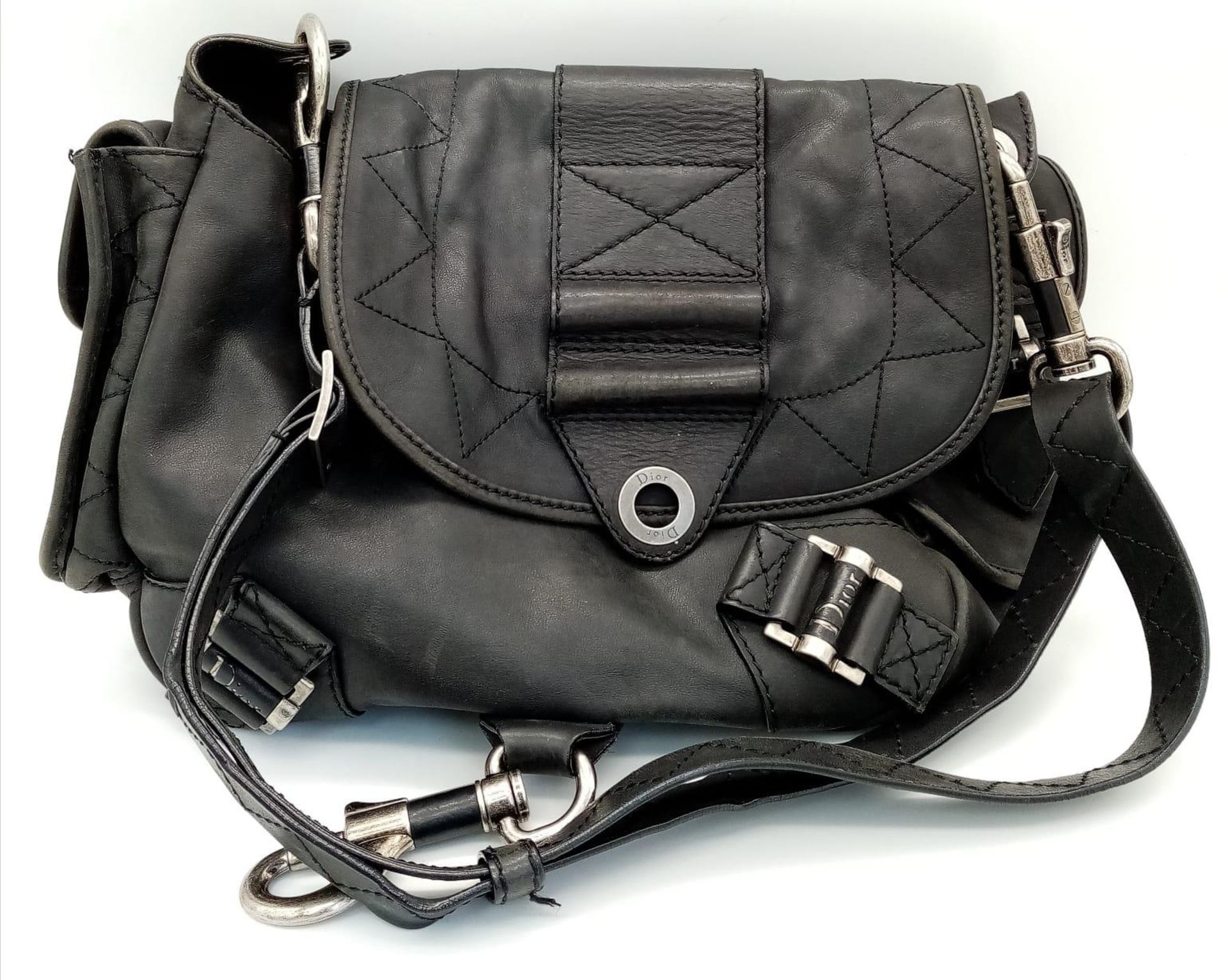 A Christian Dior Black Leather Handbag. Silver tone hardware. Chunky clasp lock. Two exterior side