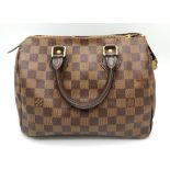 A Louis Vuitton Speedy Bag. LV canvas with brown leather trim and handles. Lock with keys. Red