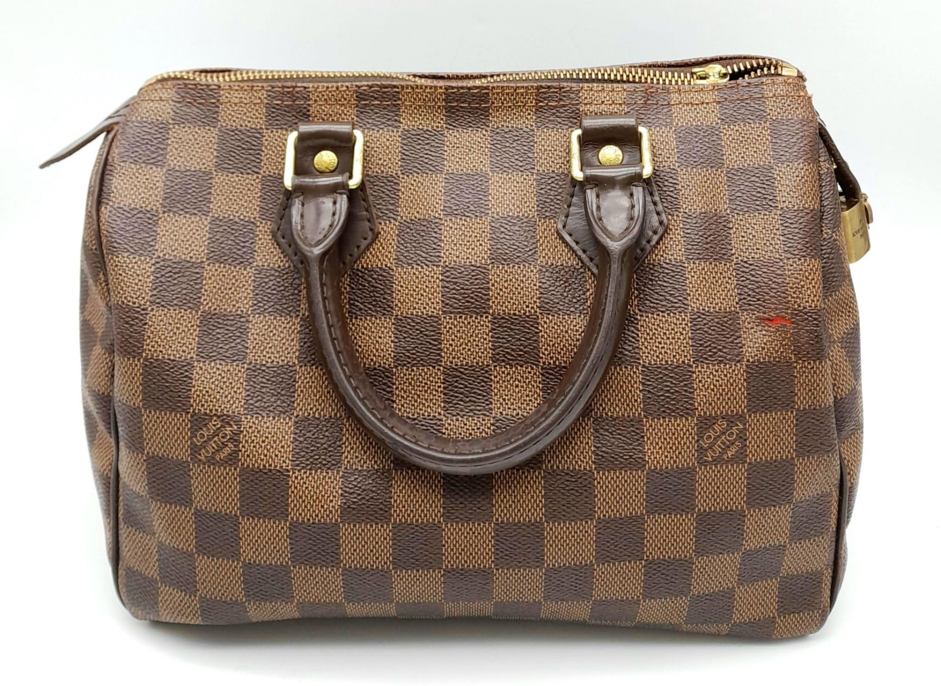 A Louis Vuitton Speedy Bag. LV canvas with brown leather trim and handles. Lock with keys. Red
