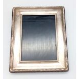 A Vintage 925 Sterling Silver Picture Frame. 13cm x 10cm. Set in wood.