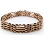 A FOUR ROW VINTAGE SEMI GATE BRACELET IN 9K ROSE GOLD WITH SAFETY CHAIN .17.1gms