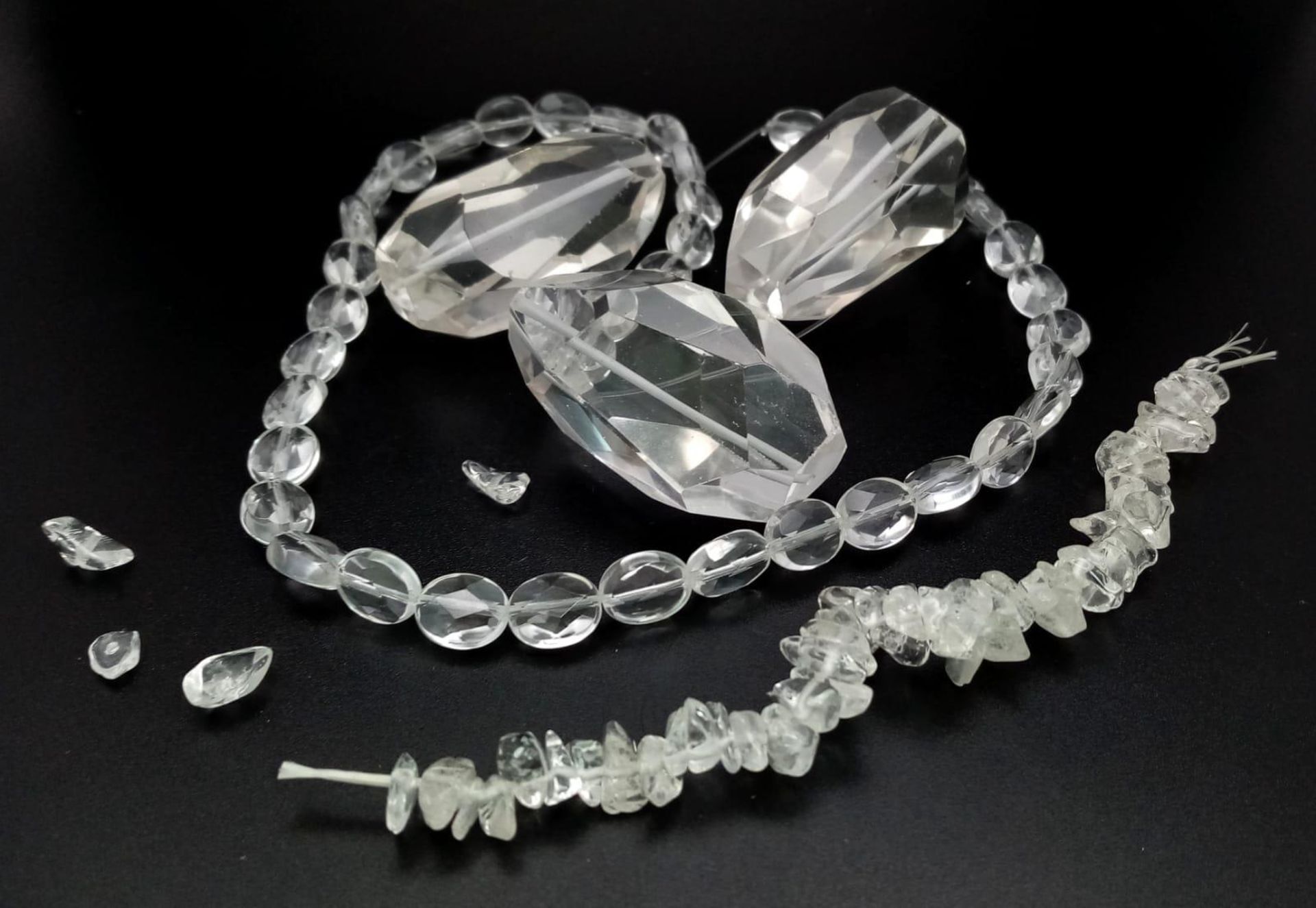 Three large (43 x 22 x 20 mm) faceted glass beads, a strand of faceted oval glass beads, 41 cm and a