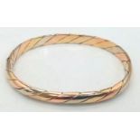 A Vintage 9K Tri-Colour Gold Bangle. Yellow, rose and white gold diagonal strip decoration. Clip