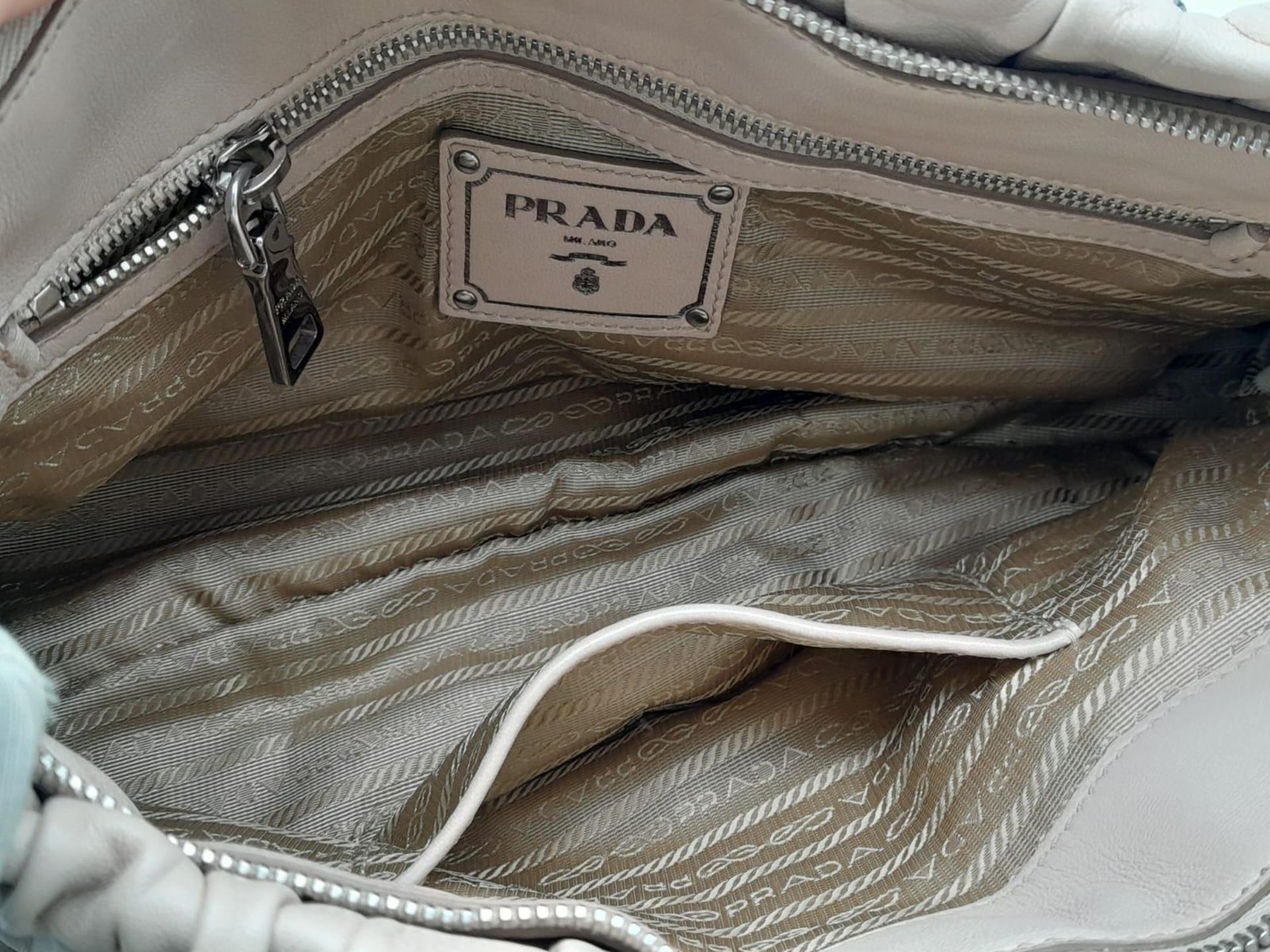 A PRADA BEIGE NAPPA LEATHER GAUFRE POMICE TOTE BAG. SILVER TONE HARD WEAR INCLUDING BUCKLE DETAIL. - Image 13 of 27