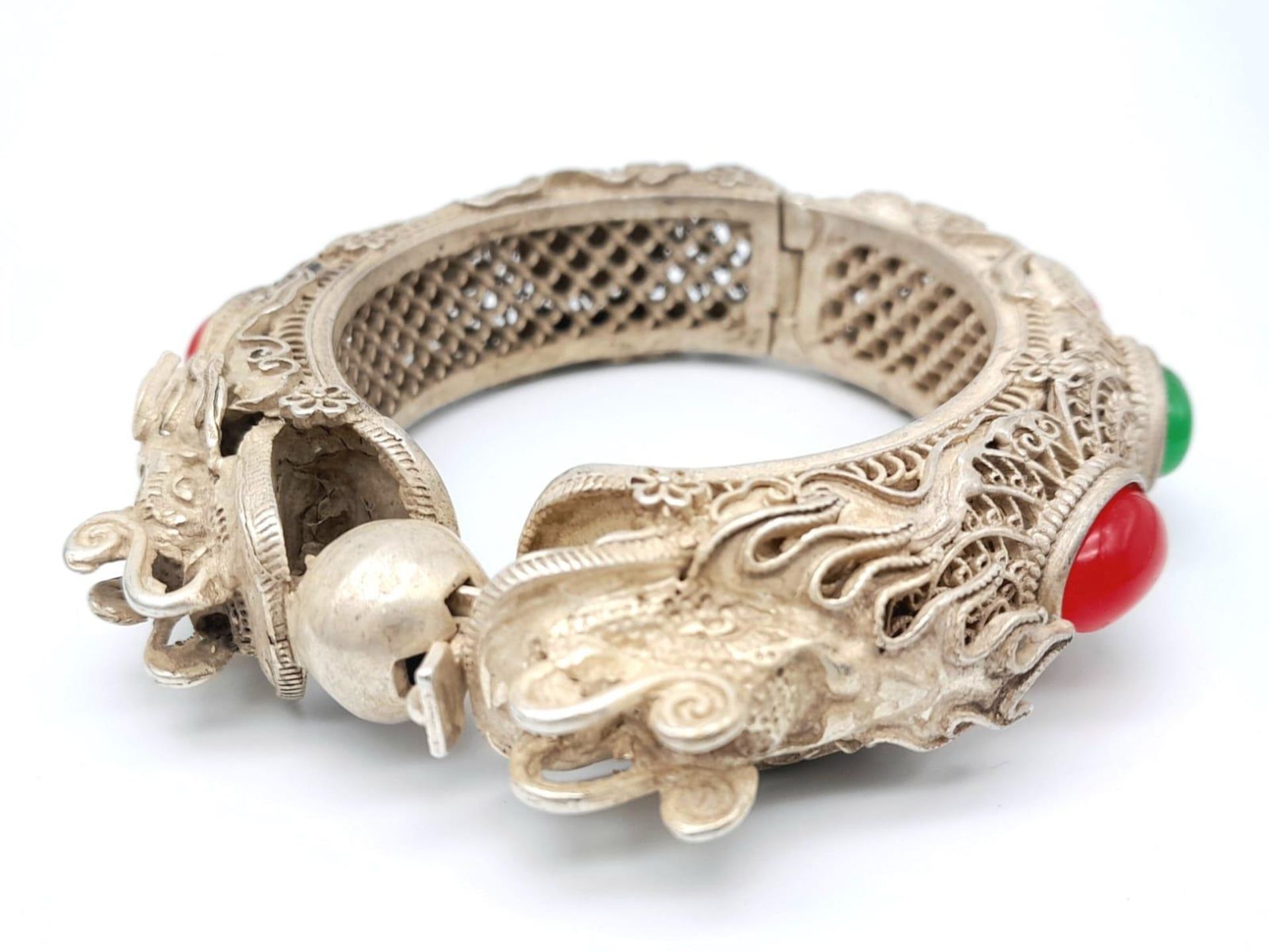 An antique, Chinese silver, filigree bangle, in the shape of two dragons with green and red jade - Image 2 of 4