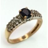 A 9K Yellow Gold Sapphire and Diamond Ring. Central oval sapphire with diamond wings. Size J. 1.