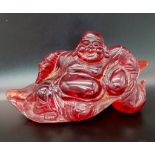 A Vintage or Older Chinese Cherry Amber Glass Buddha Seated Figure 17cm Wide.