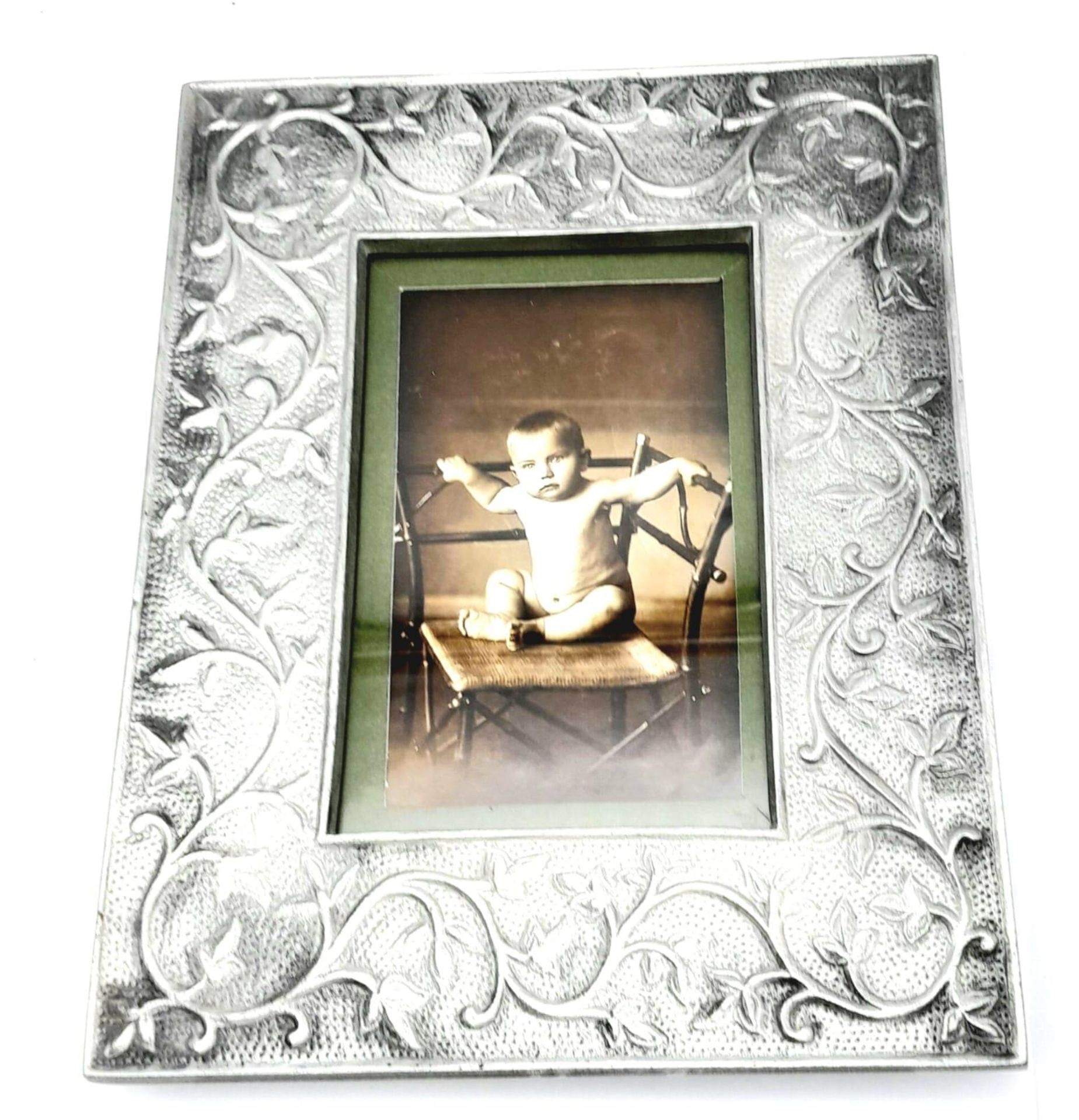 A vintage pewter photo-frame with a photo of a toddler: Donald Trump – Ex President of U.S.A. This