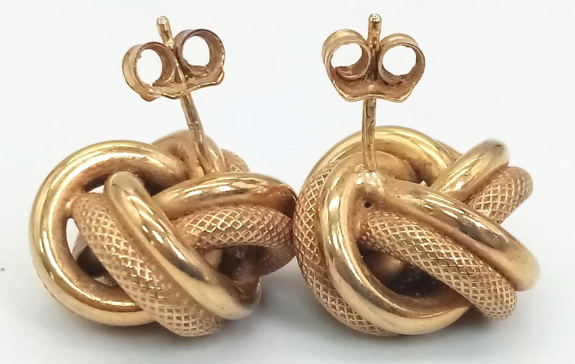 A Pair of 9K Yellow Gold Knot Earrings. Smooth and geometric patterns entwined. 4.95g total weight. - Image 2 of 3