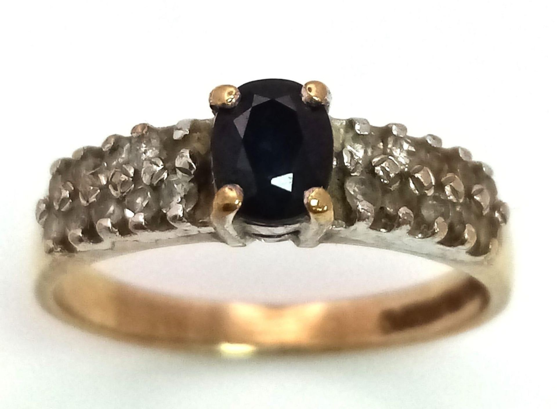 A 9K Yellow Gold Sapphire and Diamond Ring. Central oval sapphire with diamond wings. Size J. 1. - Image 2 of 4