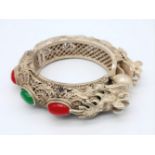 An antique, Chinese silver, filigree bangle, in the shape of two dragons with green and red jade