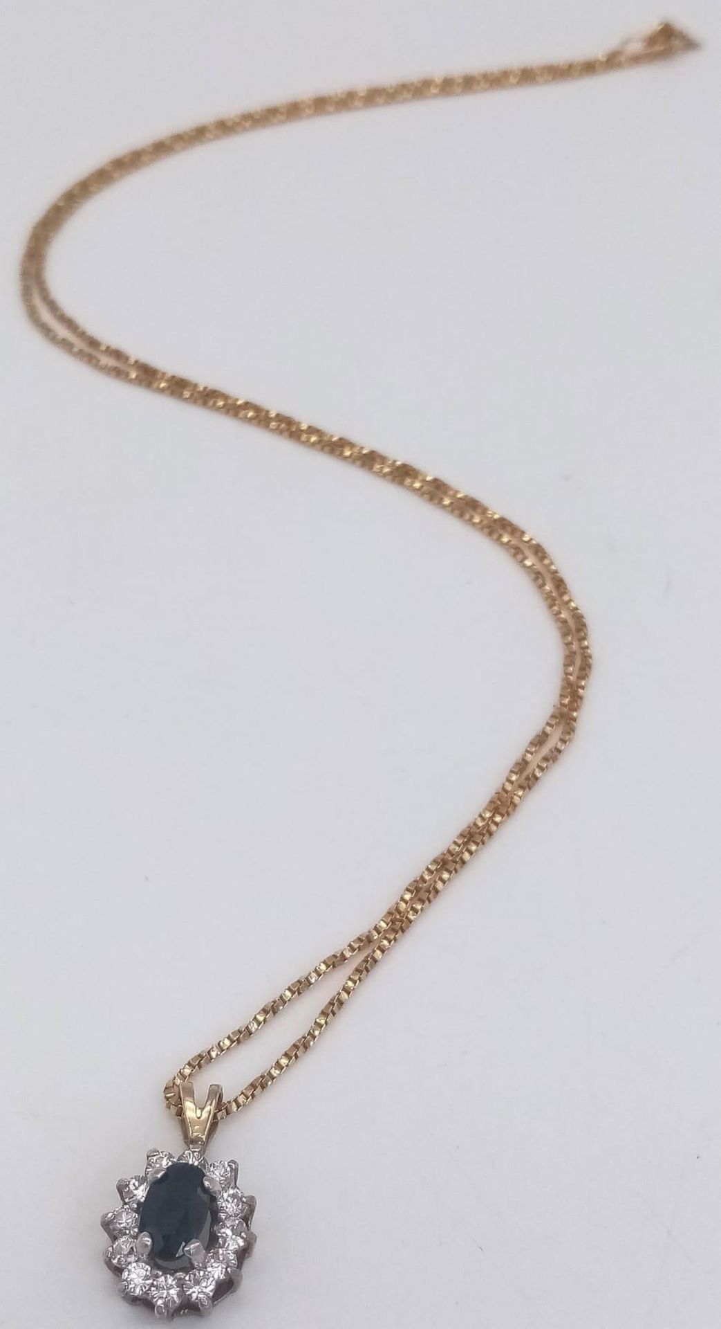 A Sapphire and Diamond Pendant set in 9K Gold on a 9K Yellow Gold Disappearing Necklace. 15mm and
