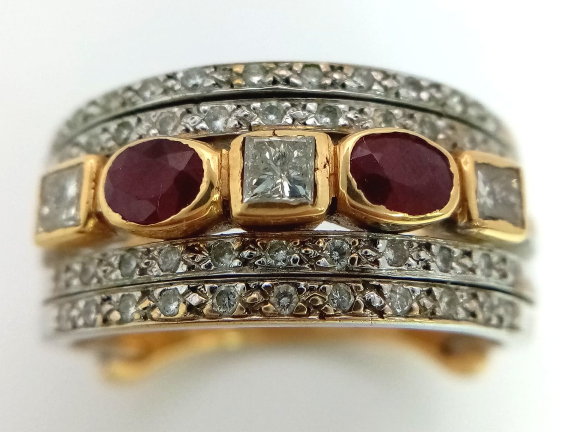 A Statement 18k Yellow, White Gold and Gemstone Band Ring. A Central reservation of oval rubies