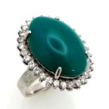 A 18K WHITE GOLD GREEN JADE CENTRE STONE SURROUNDED BY DIAMONDS RING . 0.66CT CABOCHON DIAMOND TOTAL