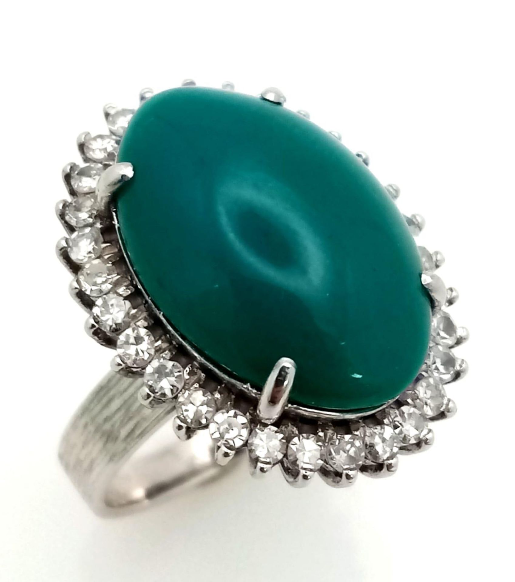A 18K WHITE GOLD GREEN JADE CENTRE STONE SURROUNDED BY DIAMONDS RING . 0.66CT CABOCHON DIAMOND TOTAL