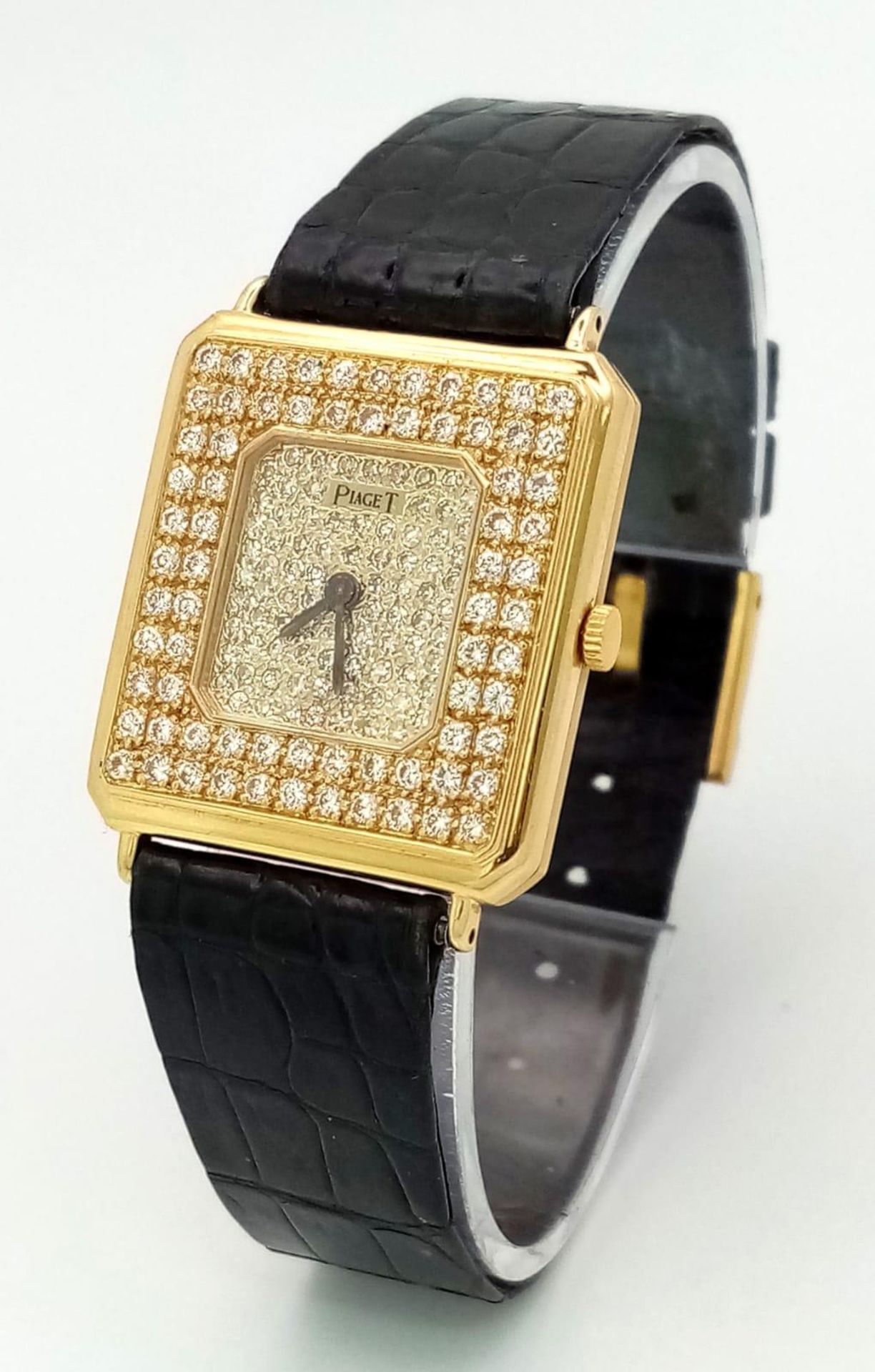 A Piaget 18K Yellow Gold and Diamond Encrusted Ladies Dress Watch. Black leather strap with Piaget