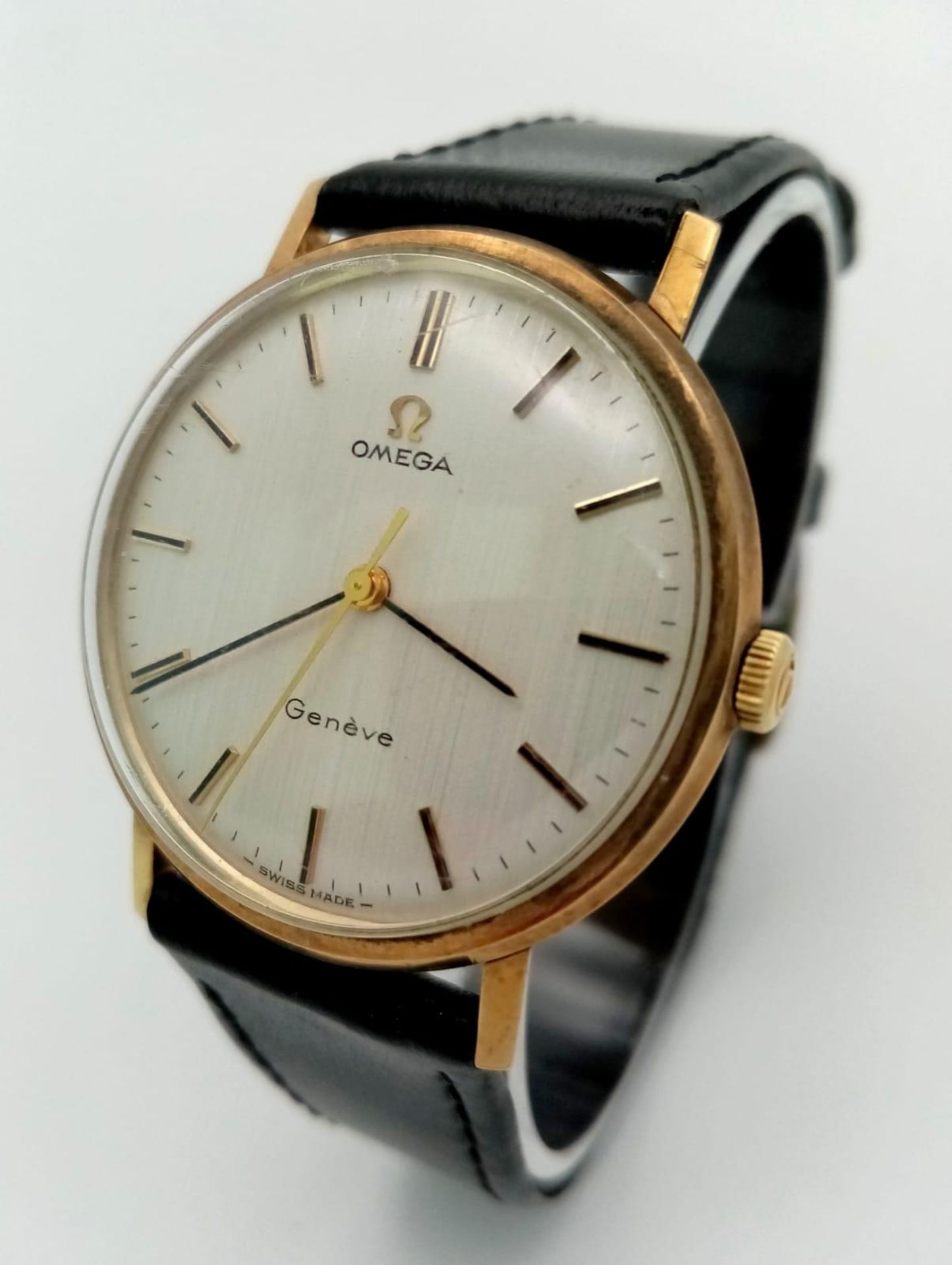 A Beautiful Vintage 9K Gold Omega Geneve Gents Watch. Black leather strap. 9K gold case - 34mm.