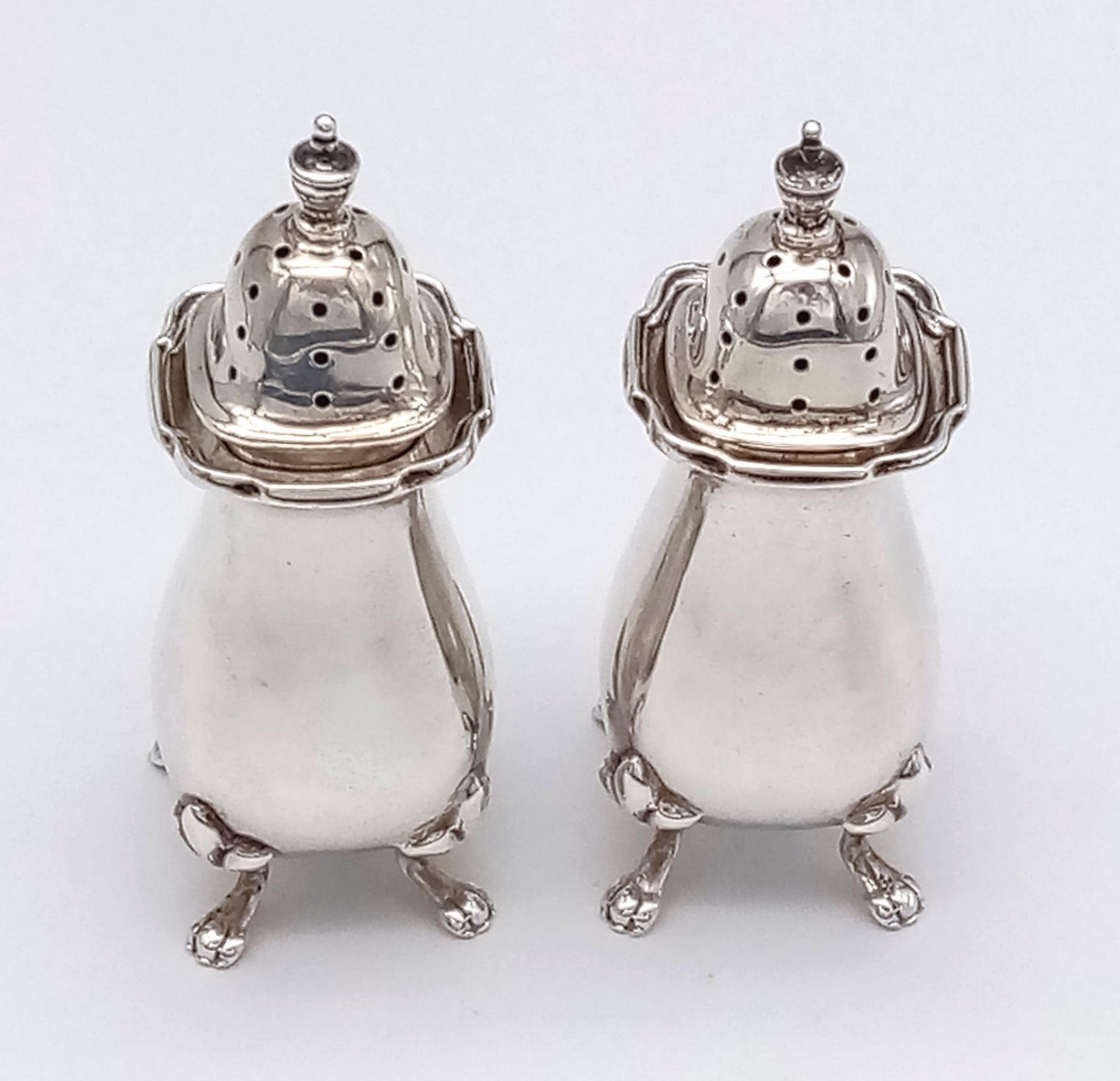 An antique pair of sterling silver pepper shakers. Full hallmarked Birmingham, 1915. Total weight