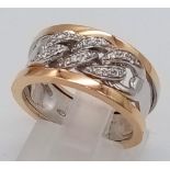 A 18K ROSE AND WHITE GOLD DIAMOND SET LINKED BAND RING. TOTAL WEIGHT 6.9G. SIZE N.
