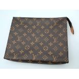 The LOUIS VUITTON Toiletry 26 Zip Pouch in Monogram. Golden-tone zip closure with leather tab.