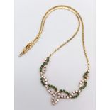 An 18K Yellow Gold Diamond and Green Stone Necklace. 40cm length with a diamond drop. 36 round cut