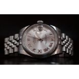 A ROLEX OYSTER PERPETUAL DATEJUST IN STAINLESS STEEL WITH SILVERTONE DIAL , ROMAN NUMERALS AND