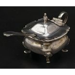 An antique sterling silver mustard pot with a white metal spoon. Hallmarked Birmingham, 1910. Silver