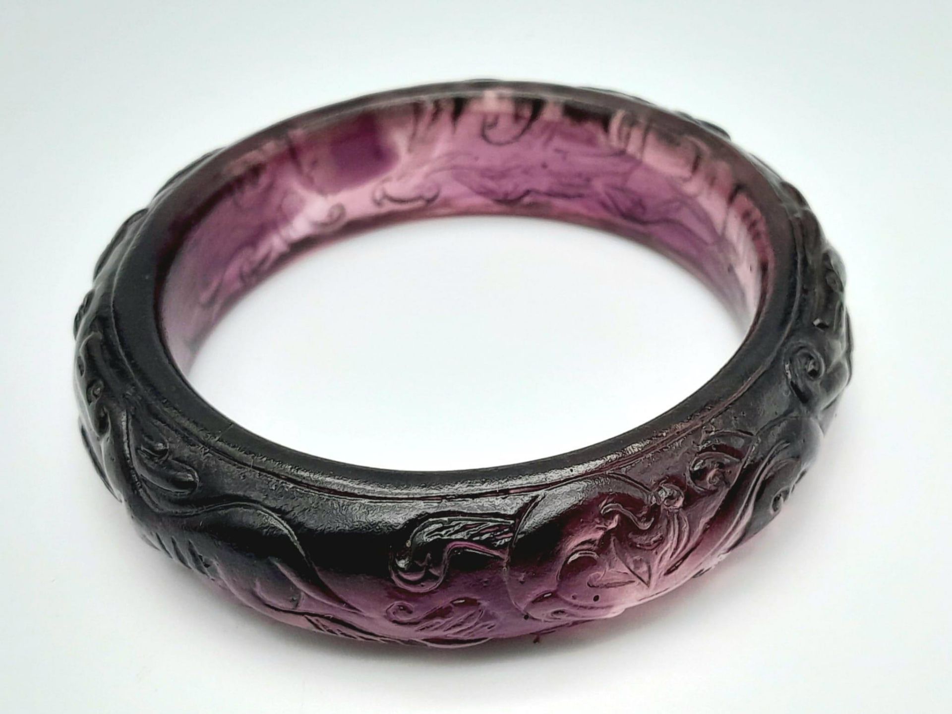 A rare, vintage, amethyst coloured PEKING GLASS bangle with carved hunting scene of dogs and
