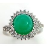 An 18K White Gold, Diamond and Jade Cabochon Ring. A beautiful pale green jade cabochon with a