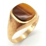 A GENTS SIGNET RING WITH TIGERS EYE STONE. 3.6gms size V