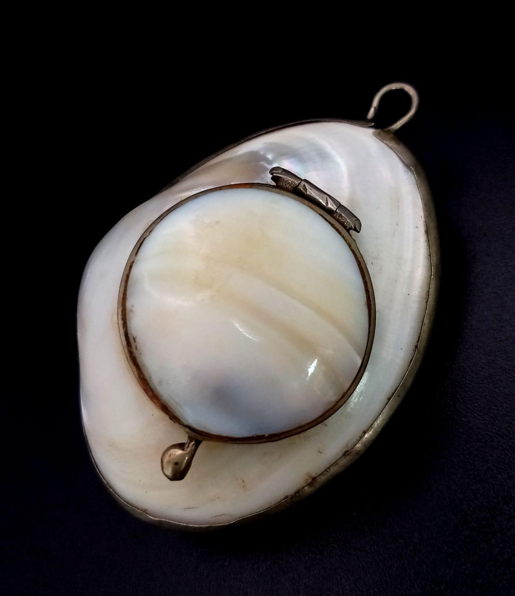 A rare, antique, probably Victorian, pill box pendant made of mother of pearl and silver.