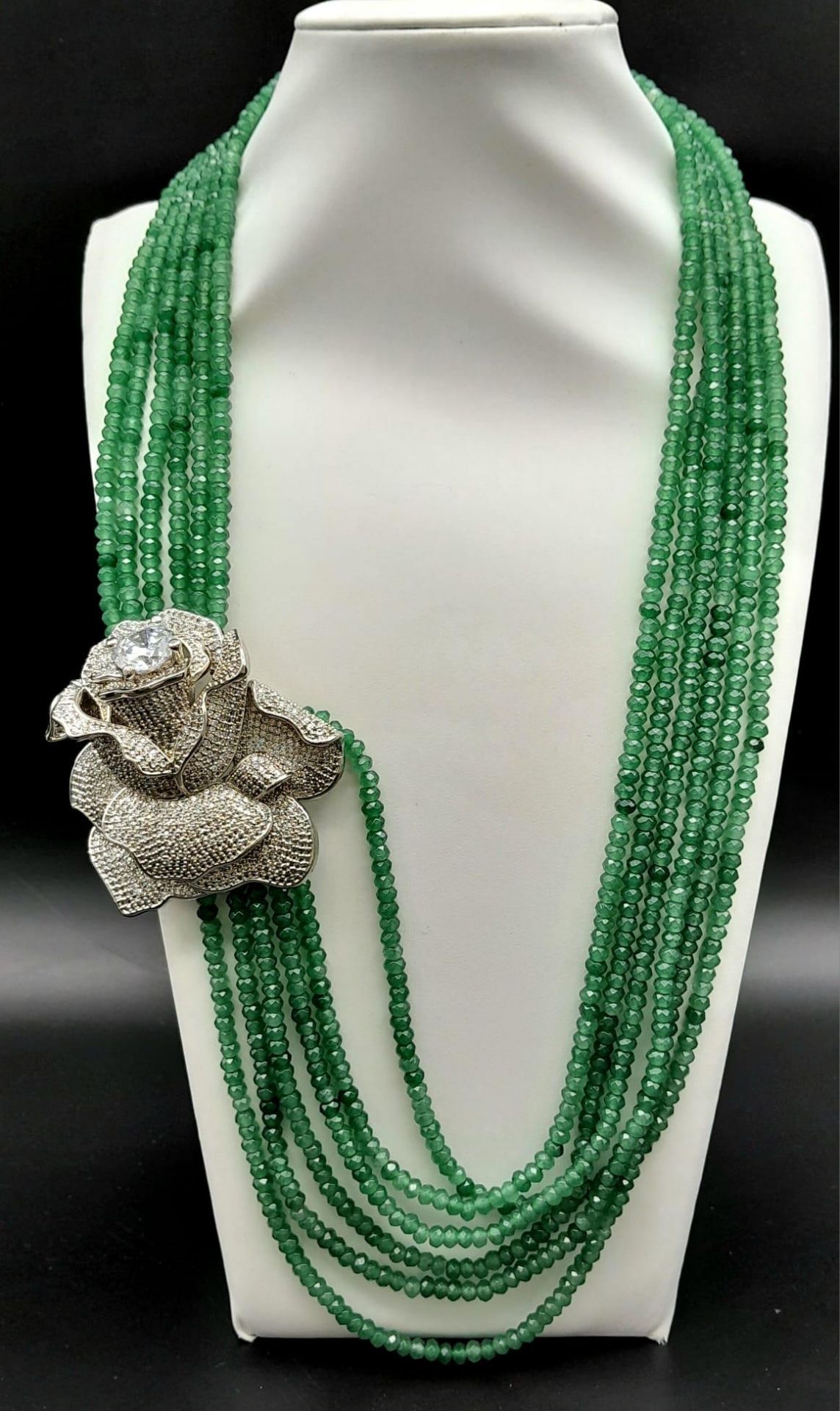 An impressive, six row necklace with faceted emerald beads and highly ornamental, white metal (