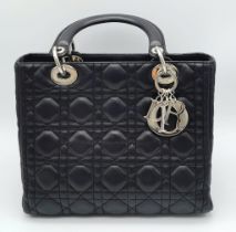 The Season's Lady Dior bag by Christian Dior is crafted from black quilted Lambskin leather. The