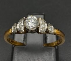 An 18K Yellow Gold Diamond Ring. Central brilliant round cut diamond with two round cut diamonds