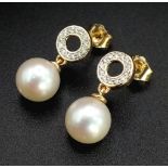 A pair of 9K yellow gold cultured pearl droplet earrings with diamond halo bales. 0.15ct. Boxed.
