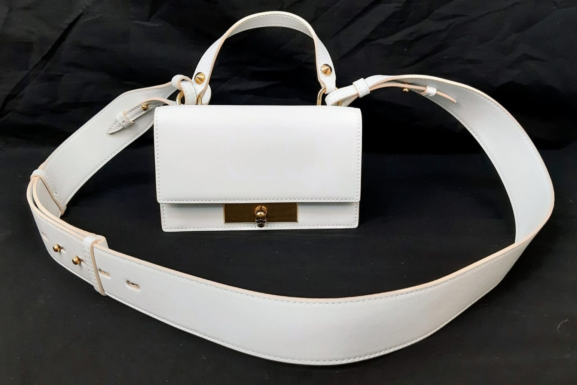 An Alexander McQueen Deep Ivory Leather Clutch Bag with Gold Skull Detail. Beige Suede Interior,