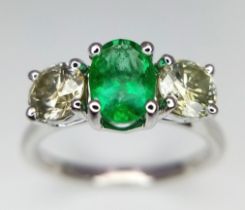 A WGI certified 18K white gold emerald and diamond trilogy ring. Oval mixed cut natural emerald