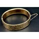 A 9K GOLD NICELY DECORATED CUFF BANGLE WITH SAFETY CHAIN . 22.5gms