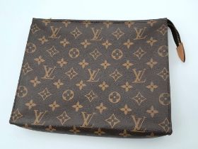 The LOUIS VUITTON Toiletry 26 Zip Pouch in Monogram. Golden-tone zip closure with leather tab.