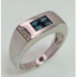 A Stylish 9K White Gold, Sapphire and Diamond Ring. Four small square cut sapphires and eight