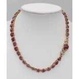 A vintage, 9 K yellow gold necklace loaded with oval cut natural rubies and round cut diamonds.