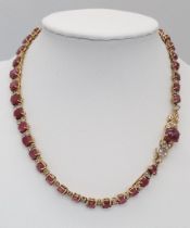 A vintage, 9 K yellow gold necklace loaded with oval cut natural rubies and round cut diamonds.