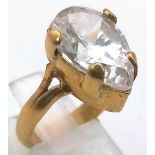 An 18K Yellow Gold Moissanite Ring. Large faceted central pear-shape moissanite. Size I. 7.11g total