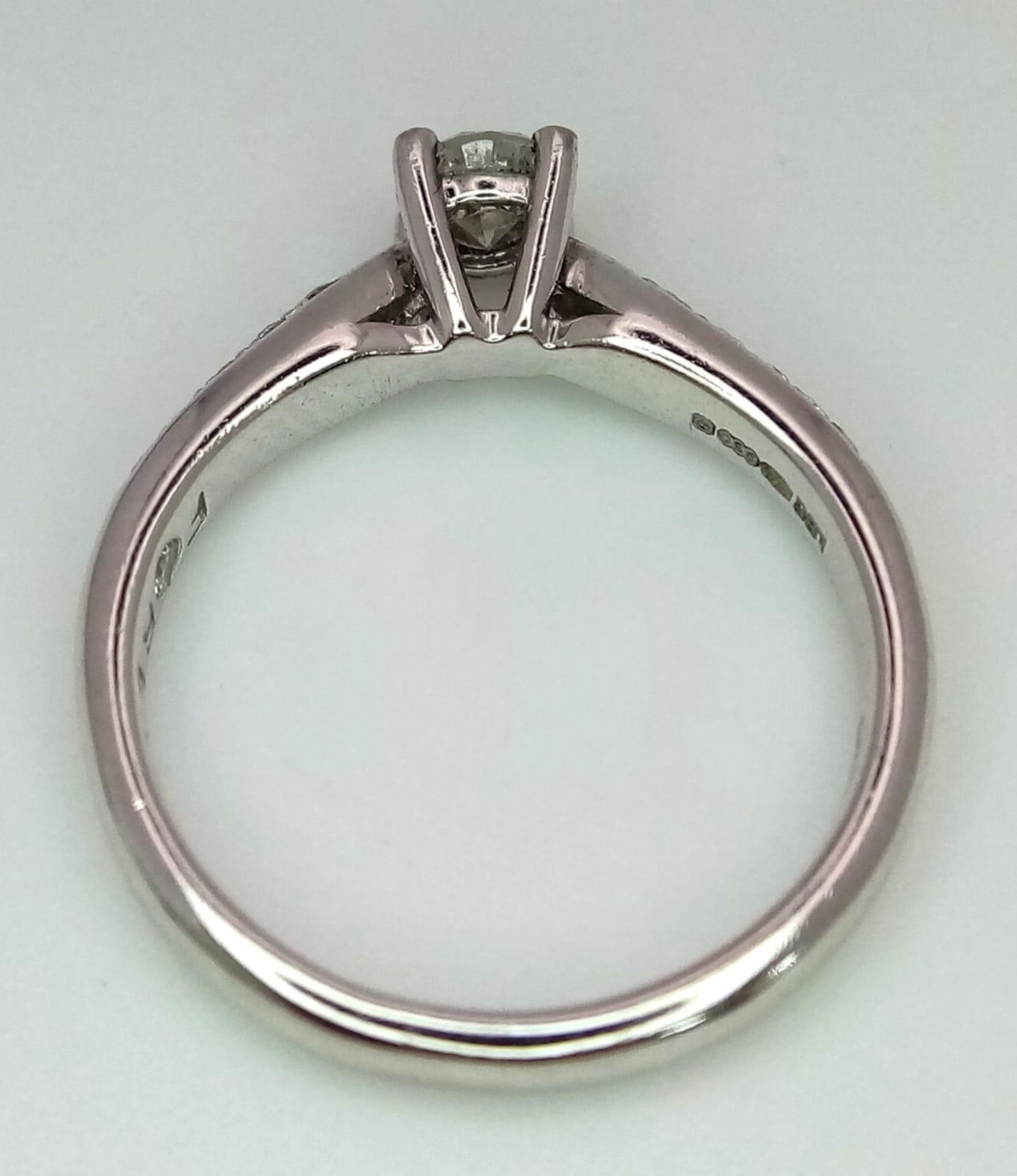 A PLATINUM DIAMOND SOLITAIRE RING WITH A ROUND BRILIANT CENTRE STONE AND DIAMOND SET SHOULDERS, - Bild 3 aus 4