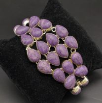 A glorious, white metal (untested), bracelet with numerous, oval charoite cabochons. In a