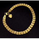 A 22K GOLD ASIAN STYLE BRACELET WITH HEART PENDANT . 11.2gms