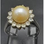 An 18K White Gold, Pearl and Diamond Ring. Central South Sea pearl with an old cut diamond halo.